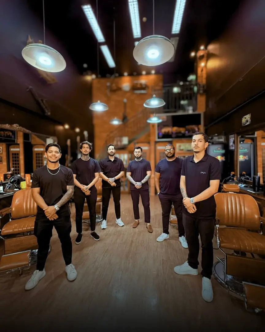 Equipe da Don Retrô em pé no salão, com as cadeiras de couro ao fundo